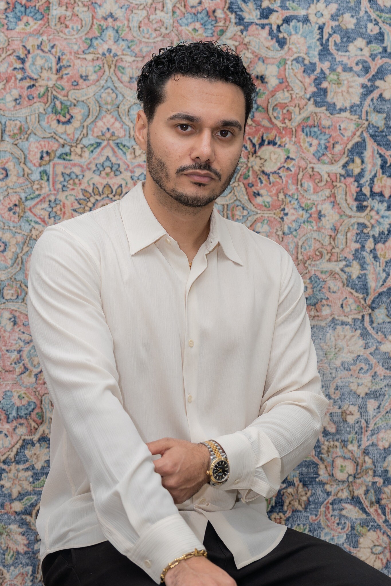 Danny Nabavi seated against a patterned rug