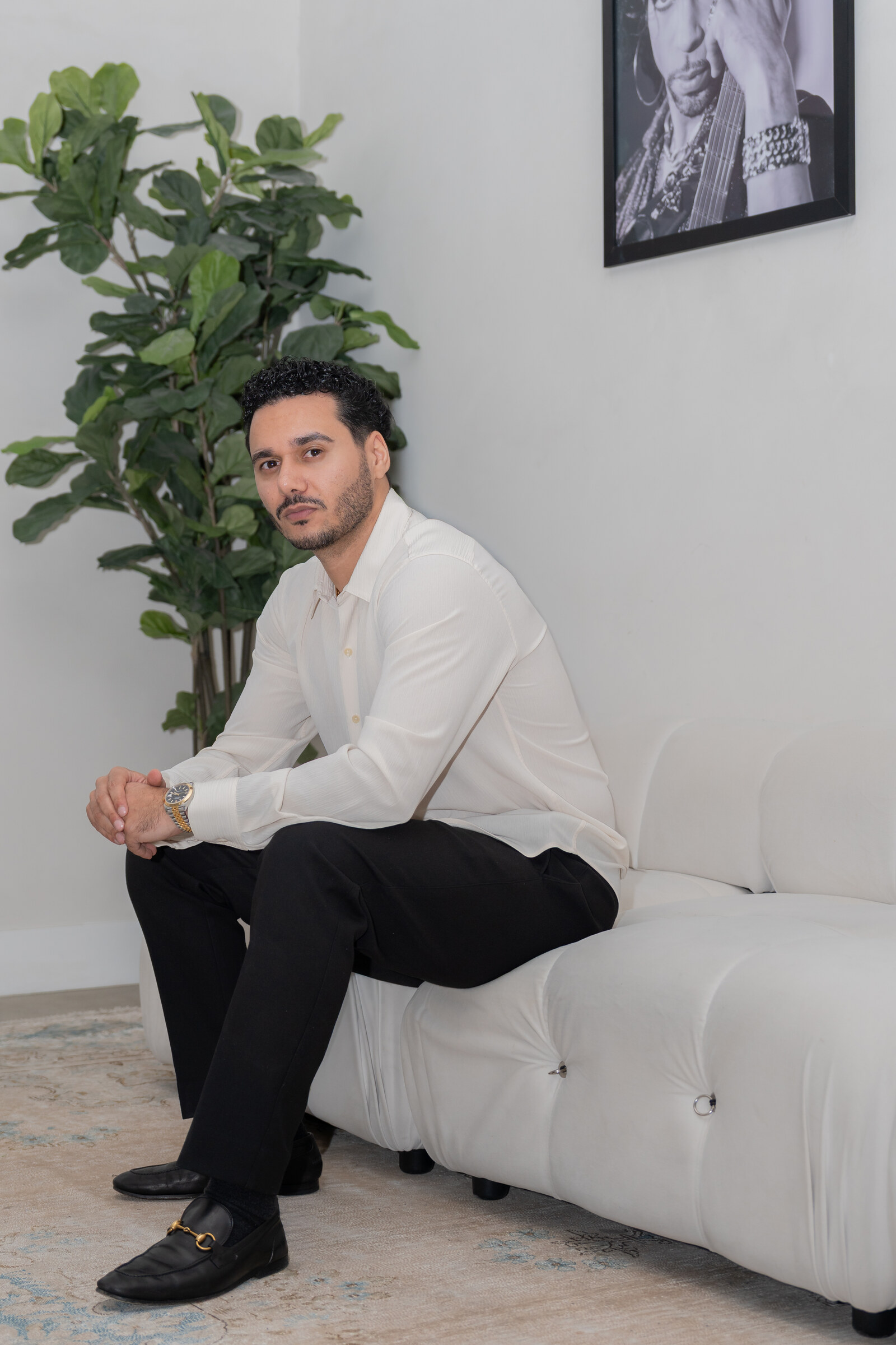 Danny Nabavi seated on a white sofa